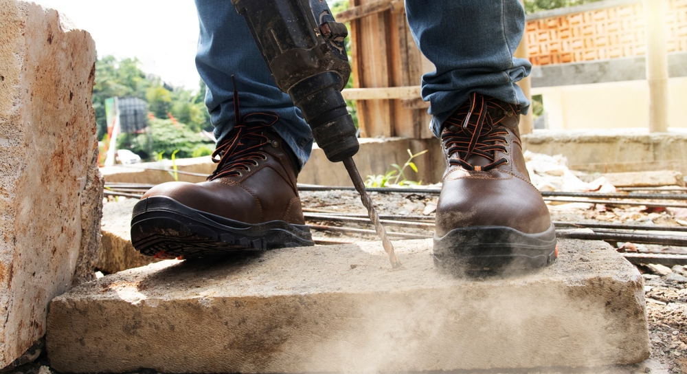 worker demonstrates foot protection at work with proper footwear