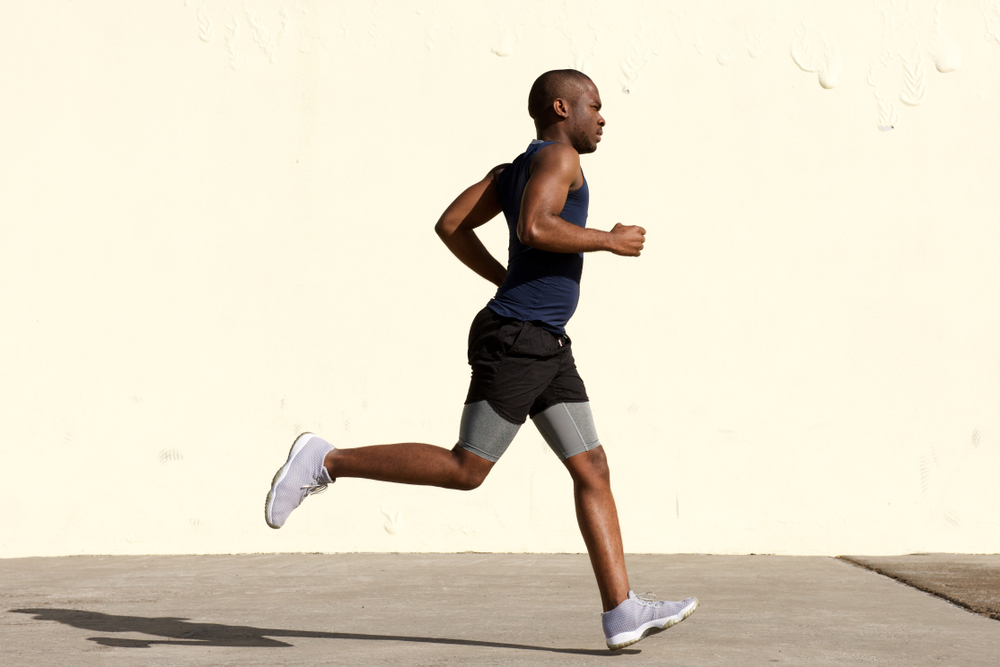 Man running outdoors, showcasing healthy foot movement.